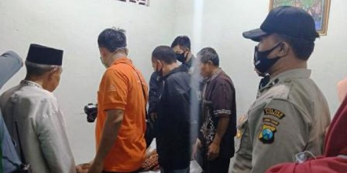 Petugas saat di rumah korban  memeriksa kondisi jenazah.

