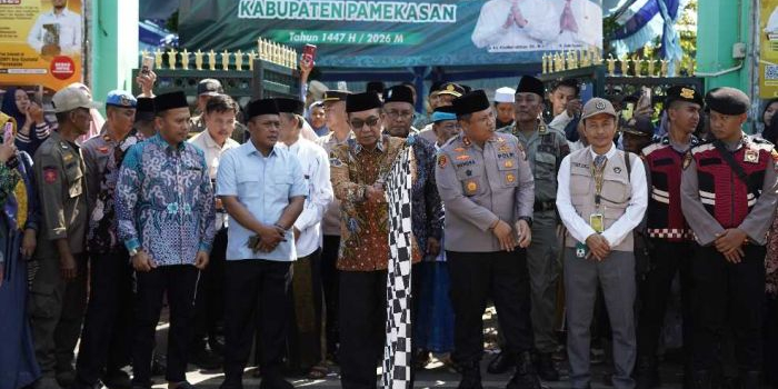 Bupati Pamekasan, Kholilurahman (pegang bendera) saat akan melepas keberangkatan jemaah haji