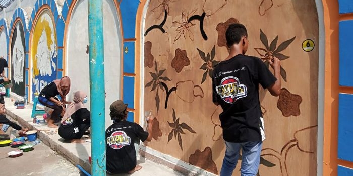 Para seniman mural saat menghias tembok GOR Rangga Jaya Anoraga dengan motif batik khas Tuban.