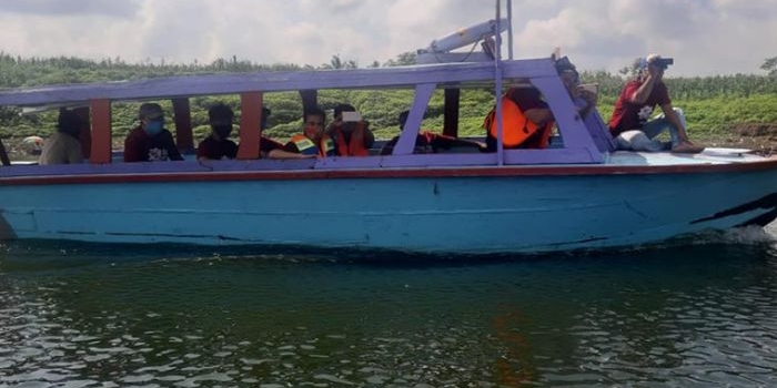 Pengunjung wisata sedang keliling Waduk Selorejo menggunakan perahu mesin.
