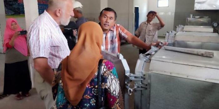 Budi Rianto Sudarsono saat menjelaskan ke tamunya orang Belanda tentang cara pengoperasian mesin pengalengan ikan di Sentra Pengolahan Ikan Bengkorok. foto: HERMAN/ BANGSAONLINE