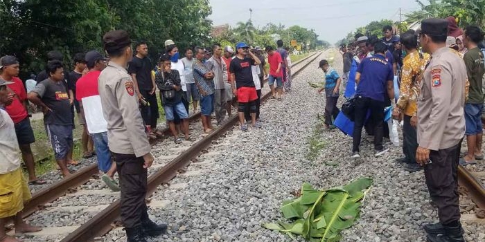 Petugas saat mengevakuasi korban tertabrak kereta api di Ngawi.