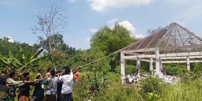 Puluhan warga Desa Winongan Kidul, Kecamatan Winongan, Kabupaten Pasuruan, ketika membongkar sebuah makam baru yang dibangun di belakang Masjid Serambi.