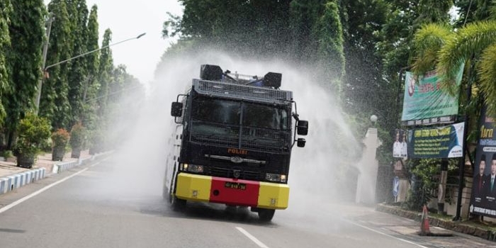 Mobil water cannon saat menyiramkan disinfektan untuk cegah virus Corona.