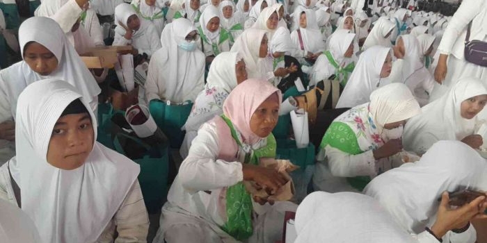 Warga asal Madura yang baru tiba di kampanye terakhir Khofifah-Emil di Jatim Expo Jalan A Yani Surabaya, Sabtu (23/11/2024). Tampak sebagaian dari mereka masih makan nasi yang disediakan panitia. Foto: Ist.