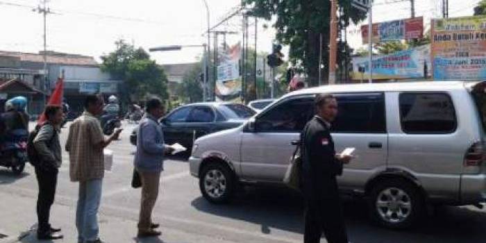 Para aktivis ketika menyebar Pamflet berisi ajakan turun jalan di Perempatan Sekarsari Mojokerto. (foto: yudi eko purnomo/BANGSAONLINE)