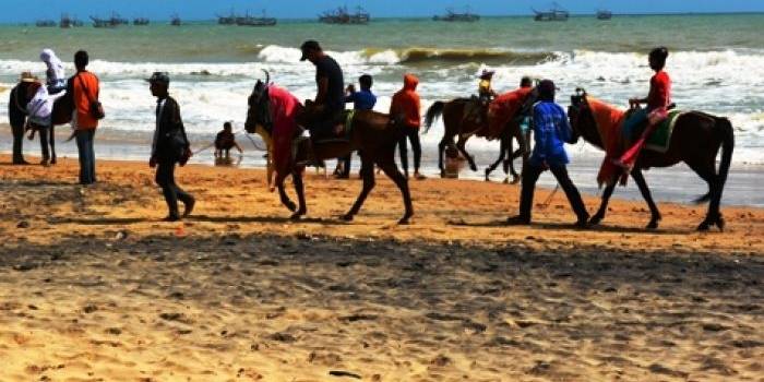 Menunggang kuda di pasir pantai Slopeng, satu wahana alami yang ditawarkan di Pantai Slopeng.foto:lukman/BANGSAONLINE