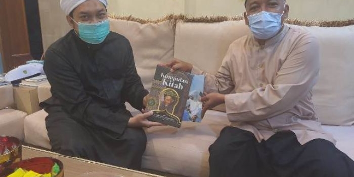 KH Fahmi Amrullah (Gus Fahmi, kanan) memberikan kumpulan kitab karangan Hadratussyaikh KHM Hasyim Asy