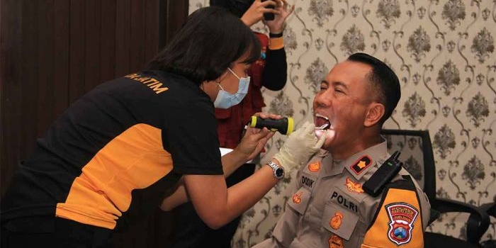 Petugas kesehatan dari Biddokkes Polda Jatim saat memeriksa gigi dan mulut salah satu personel Polres Kediri Kota. Foto: Ist