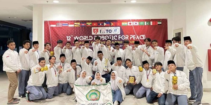 Para santri MBI Amanatul Ummah saat berpose usai berhasil meraih berbagai juara dalam banyak kategori pada 12th World Robotic For Peace di Malaysia. Foto: Ist