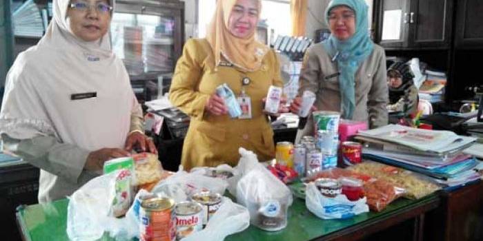 Kadinkes Kota Mojokerto, Cristiana Indah Wahyu dan stafnya menunjukan puluhan mamin yang disita dari supermarket. (foto: yudi eko purnomo/BANGSAONLINE)