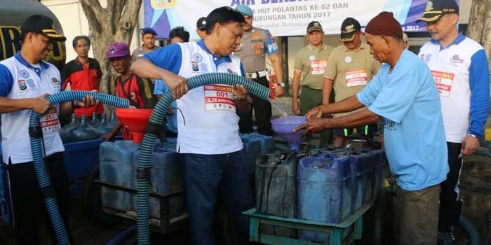 Bupati Sambari bersama Wabup Moh. Qosim dan Kapolres AKBP Boro Windu Danandito saat menyalurkan air bersih. foto: SYUHUD/ BANGSAONLINE