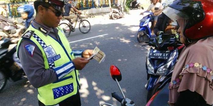 Petugas saat memeriksa kelengkapan kendaraan salah satu pengendara motor. foto: tri susanto/ BANGSAONLINE