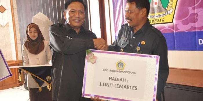 Bupati Gresik Sambari Halim Radianto memberikan hadiah kepada Camat Balongpanggang karena paling banyak desanya lunas PBB selama Periode Agustus-Desember 2016. foto: SYUHUD/ BANGSAONLINE