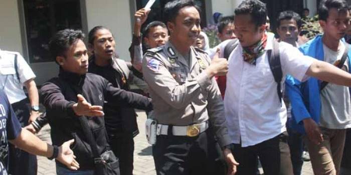 Sejumlah mahasiswa saat meminta salah satu petugas kepolisian meninggalkan areal kampus. (foto: BANGSAONLINE)