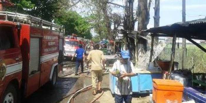 Seorang pemilik warung mengemasisisa-sisa barangnya yang tertinggal. Foto:yudi eko purnomo