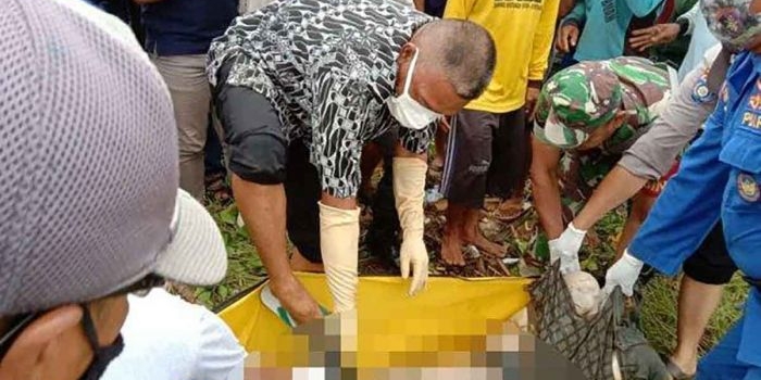 Petugas saat mengevakuasi mayat yang ditemukan warga di pinggir Sungai Bondoyudo, Jember.