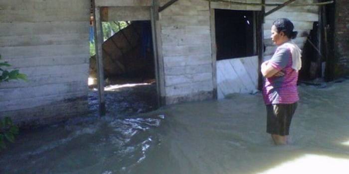 ?Warga mengamati rumah yang diterjang banjir. Foto:eky nur hadi/BANGSAONLINE