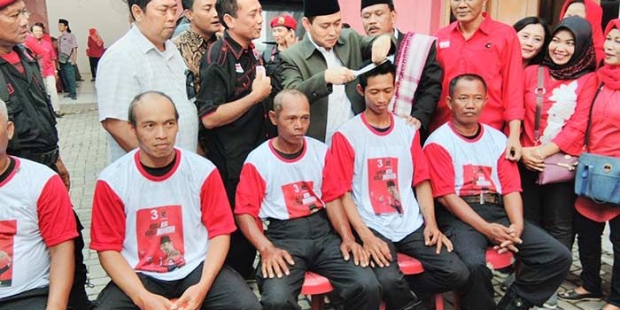 Secara simbolis, Bupati dan Wakil Bupati Nganjuk saat mencukur rambut simpatisan yang akan digundul. foto: BAMBANG/ BANGSAONLINE