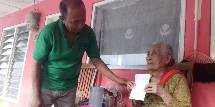 Mbok Suryo Tiami sedang menunjukkan buku rekening bank BNI miliknya. 