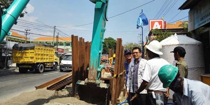 Camat Manyar Abdul Hakam ketika meminta pekerja menghentikan proyek pemasangan pipa gas. foto: SYUHUD/ BANGSAONLINE