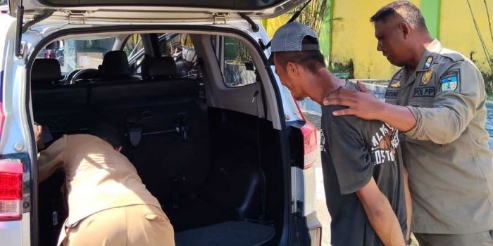 Petugas Satpol PP Kabupaten Kediri saat mengamankan seorang pria diduga ODGJ ke dalam mobil. (Ist). 