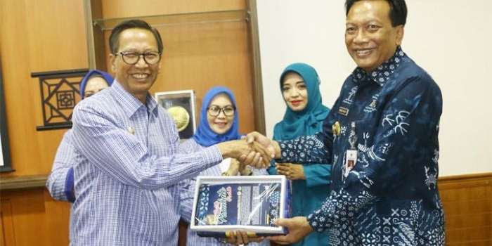 Bupati Gresik Sambari dan Wabup Polewalimandar Natsir bertukar cinderamata. foto: ist