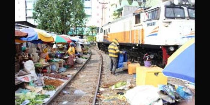 Kereta melintas, penjual pun minggir. foto: luckman hakim/BANGSAONLINE