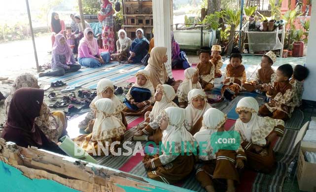 Para siswa PAUD Taman Pembinaan Anak Sholeh (TAPAS) II, di Desa Blimbing, Kecamatan Kesamben, Kabupaten Jombang saat sekolah di teras rumah warga, Jumat (2/9). foto : ROMZA/ BANGSAONLINE