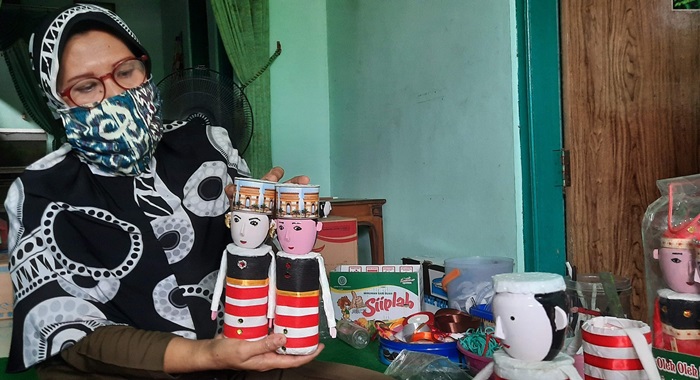Endang Supriyani sedang menunjukkan suvenir berupa sepasang boneka dari limbah botol plastik bekas minuman. foto: MUJI HARJITA/ BANGSAONLINE