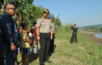 Wakapolres Sidoarjo, Aditya Puji, saat meninjau lokasi munculnya buaya di kali porong, Dusun Awar-awar. (foto: agus hp/BANGSAONLINE)