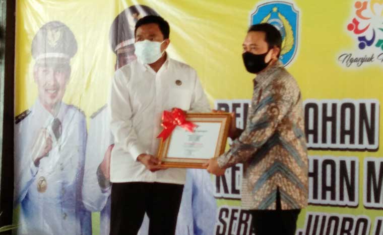 Bupati Nganjuk H. Novi Rahman Hidayat saat menetima penghargaan Desa Pangan Aman Nasional dari Kepala Balai Besar POM Surabaya, I Made Bagus Gerametta.