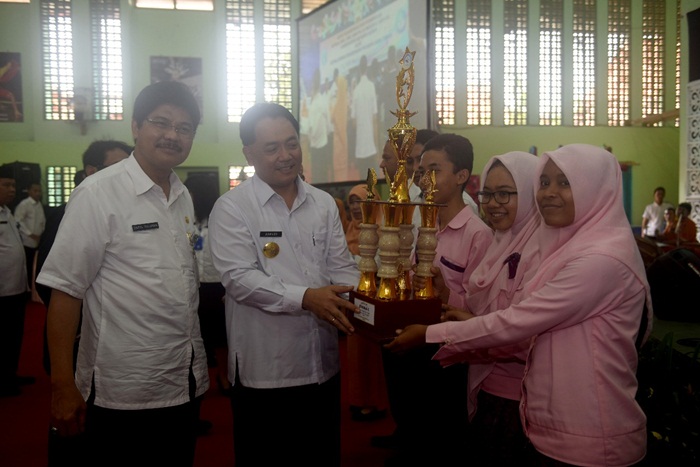 Ditemani Kadisdik Jatim, Pjs Walikota Kediri Jumadi menyerahkan throphy kepada salah satu siswa berprestasi. Foto: Arif K/BANGSAOLINE