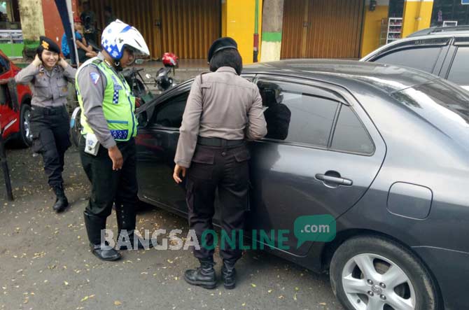 Petugas saat mengecek mobil korban di area Pasar Legi Jombang, Jumat (23/9). foto: ROMZA/ BANGSAONLINE