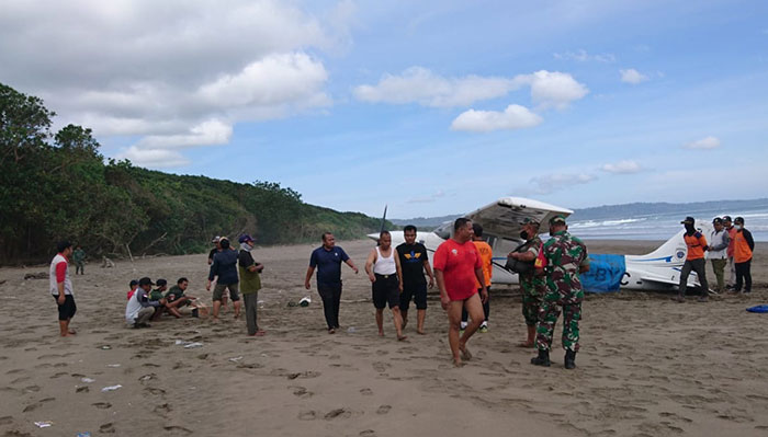 Petugas saat mengevakuasi pesawat latih cessna yang mendarat darurat di sekitar Pantai Ngagelan, Banyuwangi.
