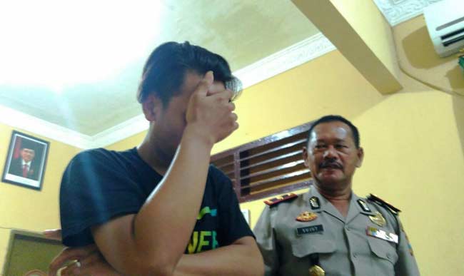 Tersangka Muhammad Rian Firdaus didampingi petugas. foto: catur 