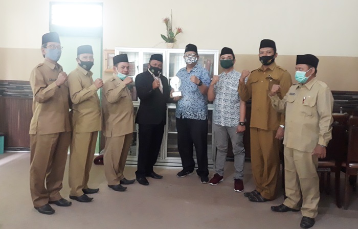 Penyerahan penghargaan oleh Forkom Jurnalis Nahdliyin Jatim kepada Markus Firdaus, Kepala Kantor Kemenag Gresik, beberapa waktu lalu. foto: istimewa
