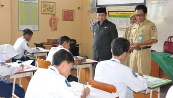 Bupati Tuban, H. Fathul Huda (berpeci) bersama rombongan ketika memantau pelaksanaan UN di beberapa sekolah. (suwandi/BANGSAONLINE)