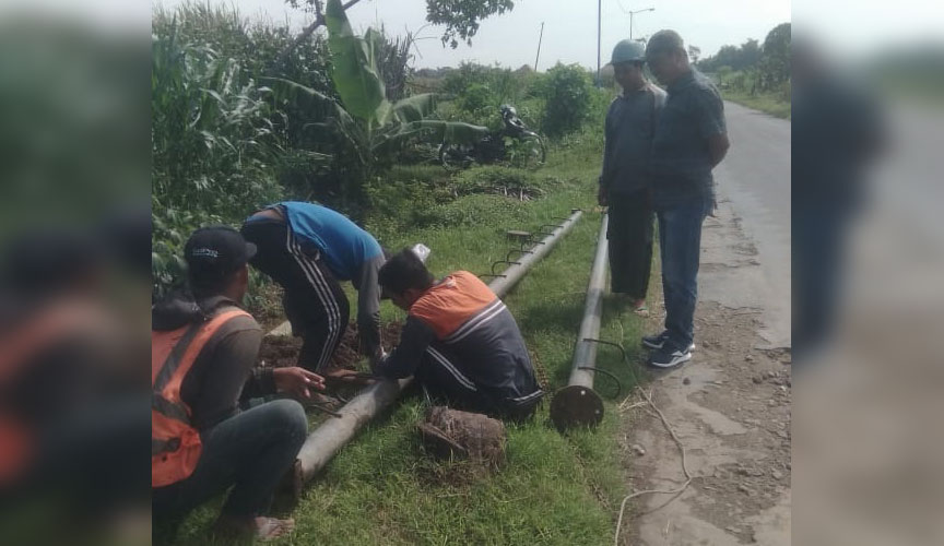 Petugas PLN saat memasang tiang listrik untuk permukiman warga terdampak proyek bandara di Kabupaten Kediri. Foto: Ist