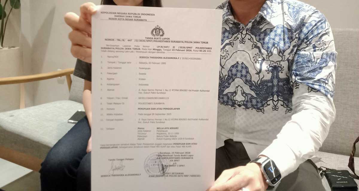 Pelapor ketika menunjukkan surat laporan polisi terkait dugaan penipuan dan penggelapan.