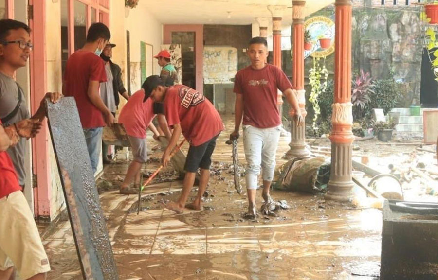 Suasana saat santri dari Pondok Pesantren Ar Rosyid Bangsalsari, Jember, membersihkan sisa banjir dan longsor.