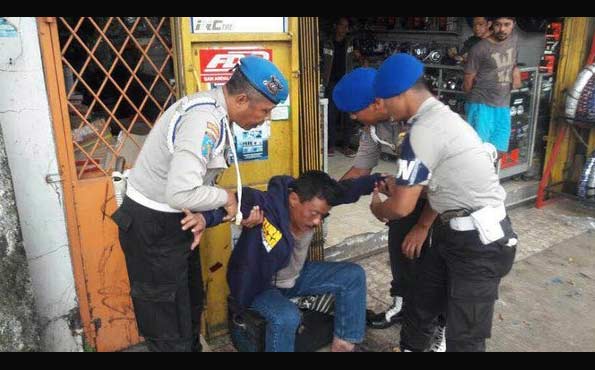 Wakapolsek Kemayoran, AKP Jamal Alkatiri yang mabuk berat dan teler saat diangkat oleh anggota propam di depan toko Jalan Otista Raya, Jakarta Timur. foto: merdeka.com