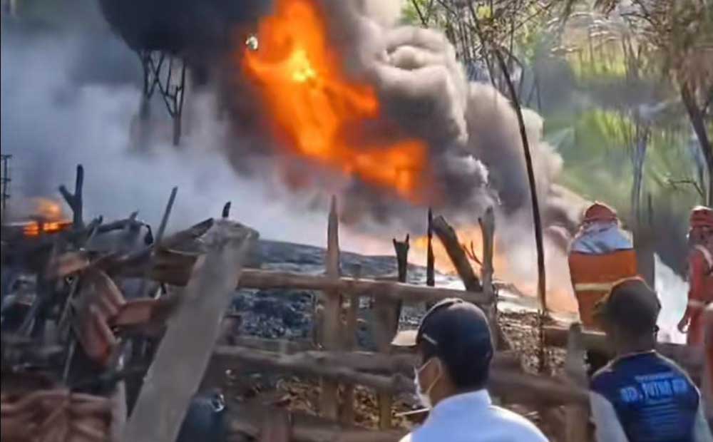 Petugas Damkar Tuban saat berupaya memadamkan kebakaran rumah warga yang dijadikan lokasi pengolahan BBM ilegal.