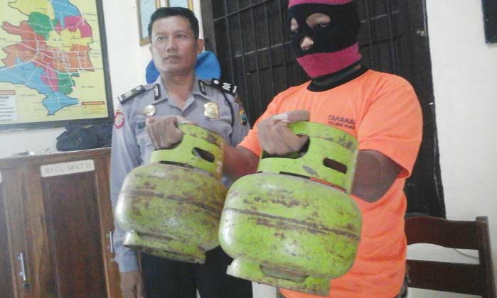 Pelaku saat menunjukkan barang bukti. (foto: dendi martoni/BANGSAONLINE)