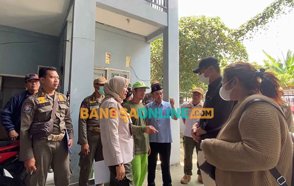Camat Kebomas, M. Yusuf Ansyori, bersama petugas dari satpol pp, Forkopimcam, dan Pemdes Randuagung saat penutupan rumah kos. Foto: SYUHUD/BANGSAONLINE