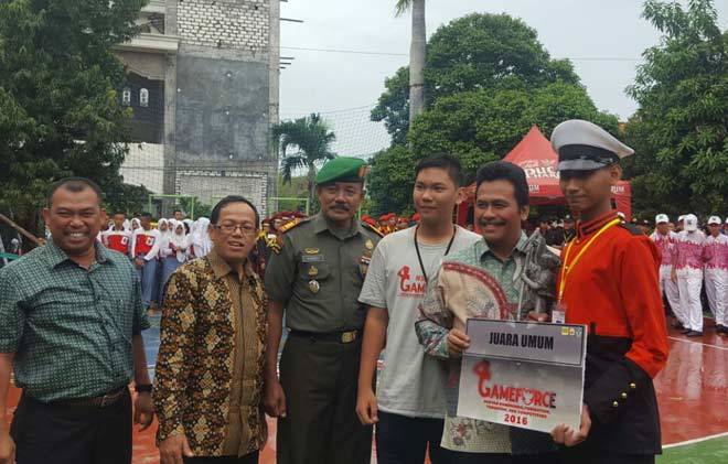 Wabup, Moh. Qosim didampingi ketua panitia Game Force, Taufik Muhamad saat menyerahkan piala bergilir kepada pemenang tim Paskibra SMAN 1 Kebomas. foto: syuhud/ BANGSAONLINE