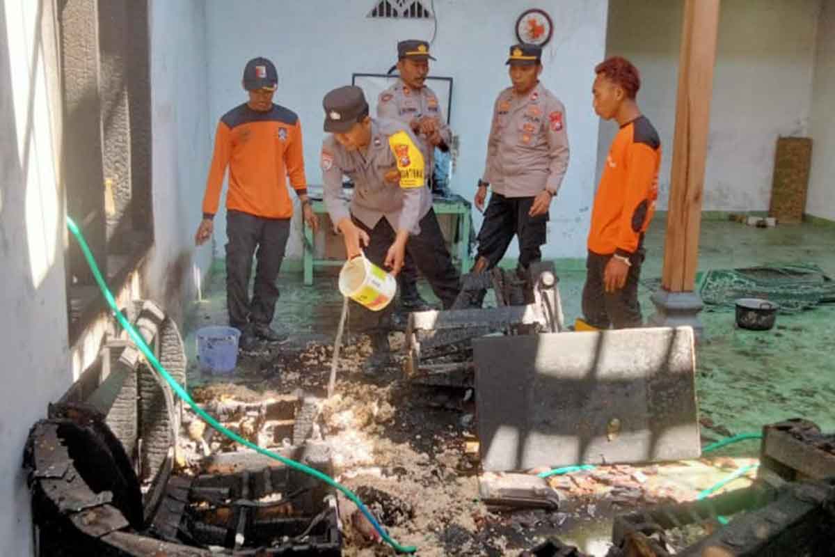 Anggota Polisi RW dari Polsek Kendal saat memadamkan kebakaran rumah warga, di Dusun Basri, Desa Sidorejo, Kecamatan Kendal, Kabupaten Ngawi, Senin (22/5/2023) malam.