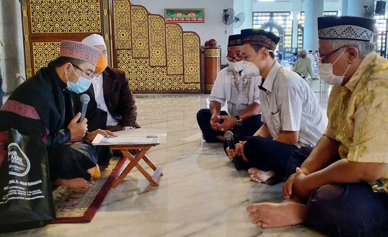 Zakaria BJ Marcello (tengah, pegang mik) didampingi dua saksi sedang mengikrarkan dua kalimat syahadat di hadapan Imam Masjid Al-Akbar Surabaya, Ustadz Nasikh Hidayatullah, Jumat (18/9/2020). foto: mma/ bangsaonline.com