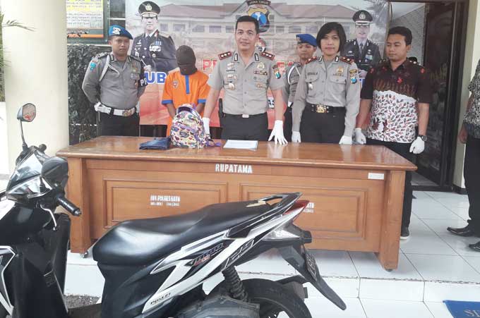 Tersangka bersama motor yang digunakan untuk 