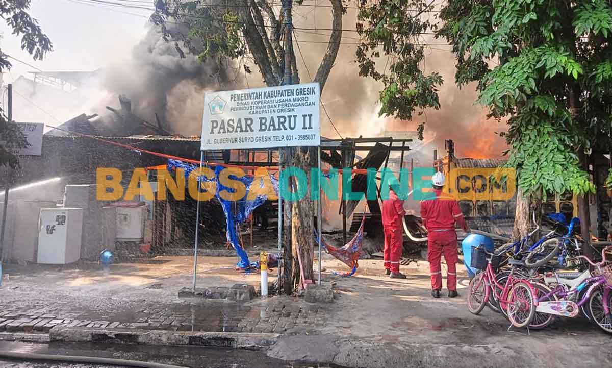 Petugas saat memadamkan kobaran api yang menghanguskan Pasar Baru II milik Pemkab Gresik. Foto: SYUHUD/BANGSAONLINE